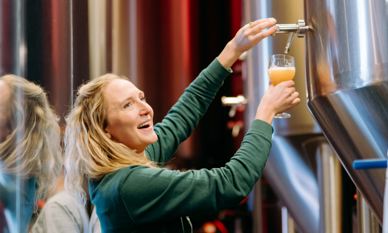 Gebrouwen door Vrouwen brouwer tapt bier uit lagertank